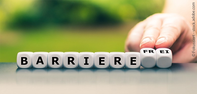 Das Wort "barrierefrei" wird auf Würfeln angezeigt, wobei die Buchstaben von "Barriere" gut lesbar nach vorne ausgerichtet sind und die Buchstaben von "frei" auf der Kippe stehen